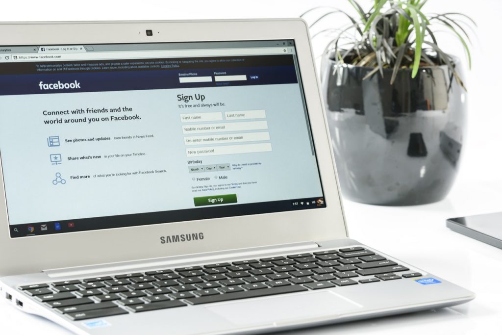 A white laptop showing a Facebook page